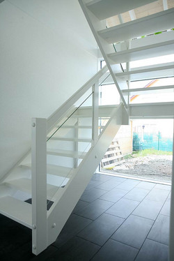 Weiße Holztreppe mit Glasgeländer